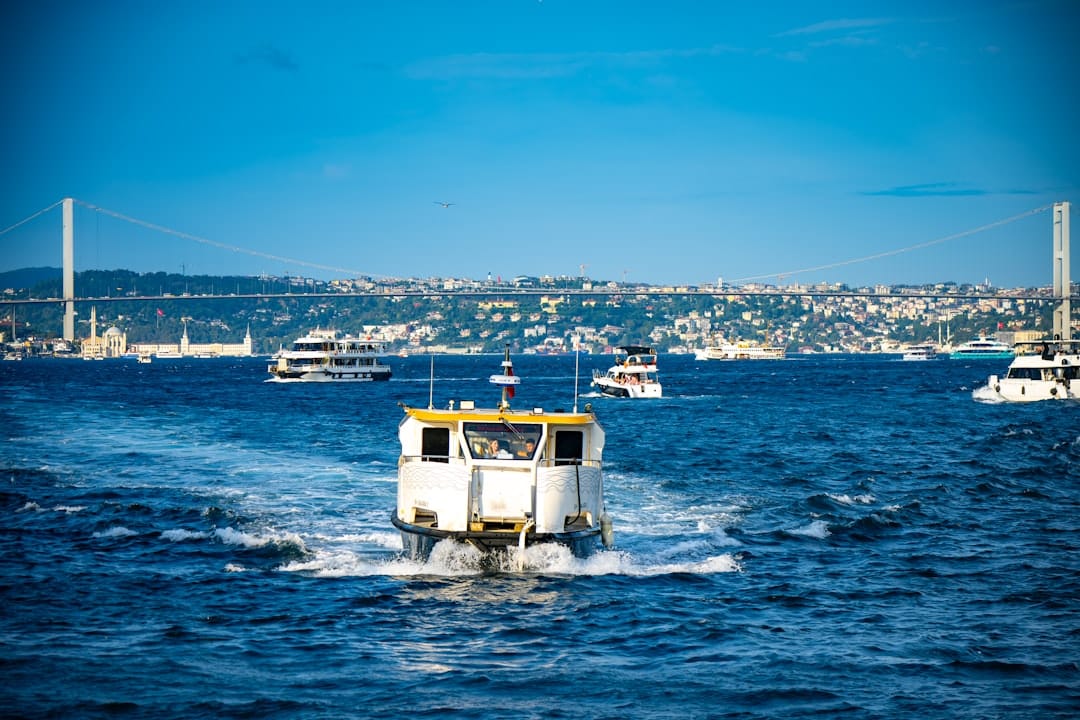 A white boat travels across a blue sea.